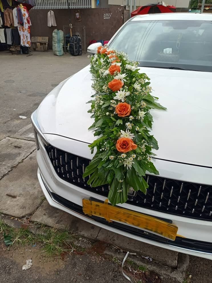 Véhicule blanc décoré de fleurs orange et de feuillage